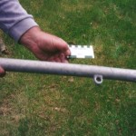 An aluminium stanchion 60cm long and 3.7 cm wide. An aluminium eye with 1.7cm internal diameter is welded to it. It has an inner post for extension with a screw threaded top. Scale in cm and inches.
